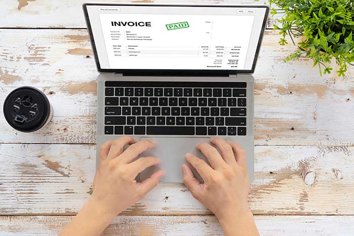 invoice on computer screen with hands on the computer keyboard